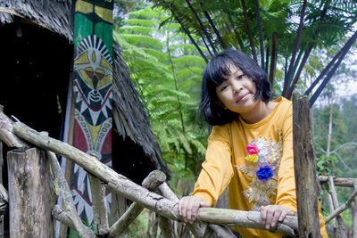 Photo of a little girl posing among the green forest scenery 