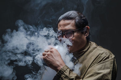 Portrait of young man smoking cigarette