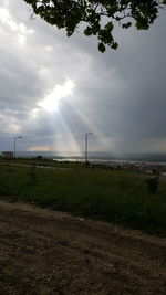 Scenic view of field against cloudy sky