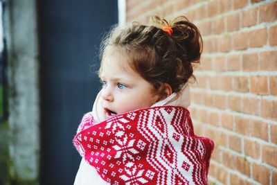 Cute smiling girl against brick wall