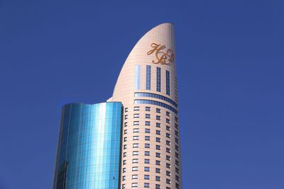 Low angle view of modern building against clear blue sky