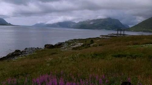 Scenic view of sea and mountains against sky