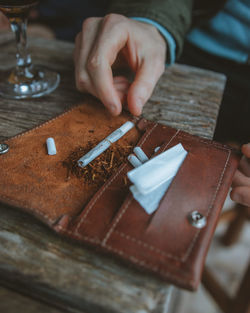 Midsection of man making cigarettes on table
