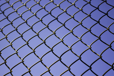 Full frame shot of chainlink fence against blue sky