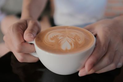 Midsection of man holding coffee cup