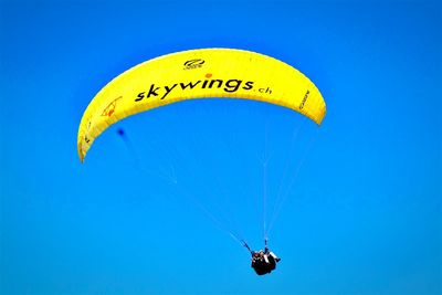 Low angle view of parachute against blue sky