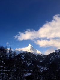 Scenic view of snowcapped mountains against cloudy sky