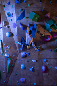 Anonymous boulderer hanging from wall ledge