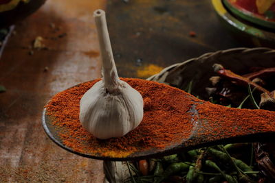 High angle view of  garlic on red pepper powder