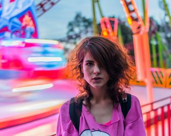 Portrait of young woman standing in amusement park