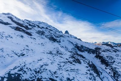 Low angle view of snow covered mountain against sky