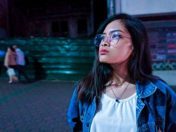 Portrait of beautiful woman standing on street in city