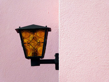 Charming view of the amber-black lamp against a light pink wall