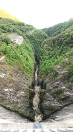 Scenic view of waterfall by mountain against sky