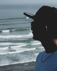 Close-up of mid adult man wearing cap against sea