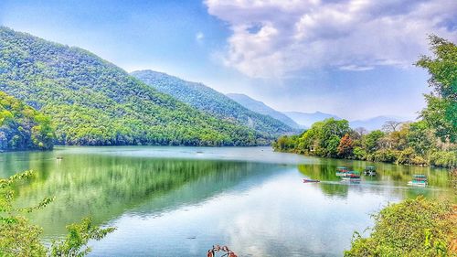 Scenic view of lake by trees against sky