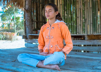 Girl meditating with eyes closed mind training in a quiet old wooden house