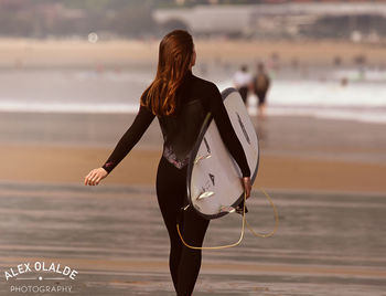 Rear view of woman standing on beach