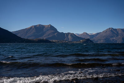 Scenic view of sea and mountains against clear sky