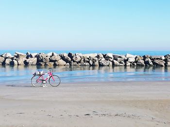 Bicycle on beach against sky