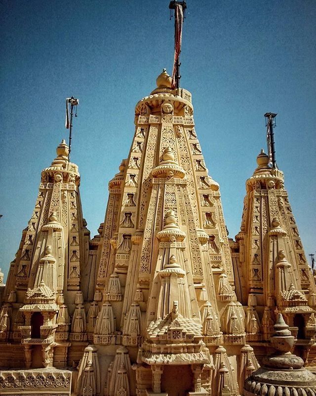 religion, place of worship, spirituality, low angle view, church, architecture, cathedral, building exterior, famous place, travel destinations, built structure, tourism, travel, human representation, statue, international landmark, sculpture, art and craft