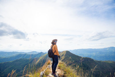 Full length of man standing on mountain against sky