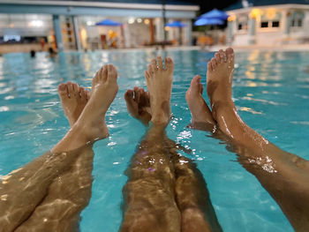 Low section of people swimming in pool