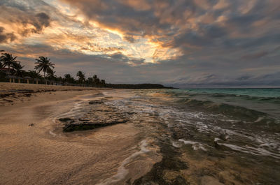 Scenic view of beach against sky during sunset