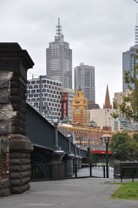 Buildings in city against cloudy sky