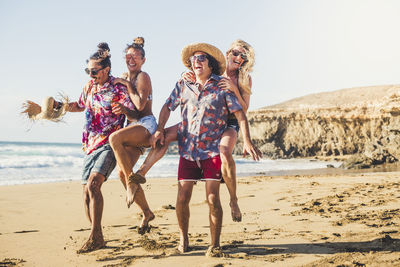 Full length of couples enjoying at beach