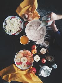 High angle view of woman preparing sweet pastry food on table