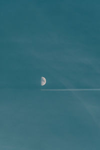 Low angle view of moon against blue sky