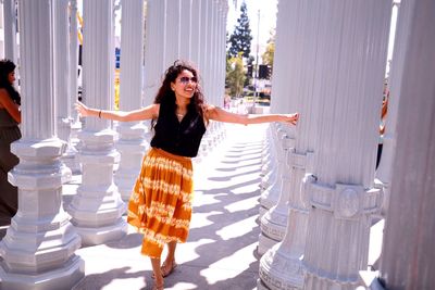 Happy young woman walking amidst urban lights at los angeles county museum of art