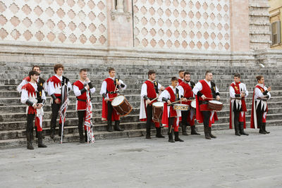 Group of people standing on cobblestone street