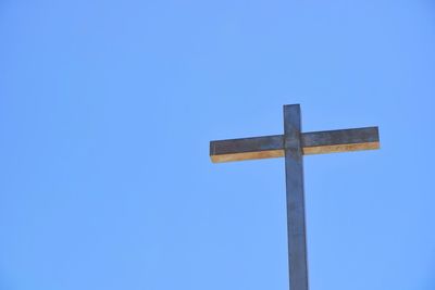 Low angle view of cross against blue sky