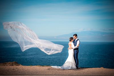 Rear view of couple kissing against sea