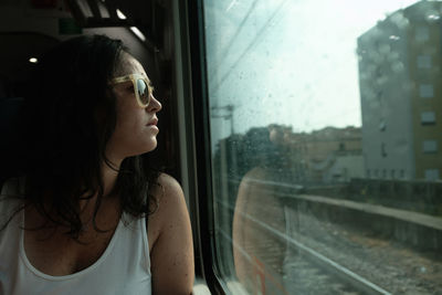 A women look thru a window in a train in movement. she's on her 30's
