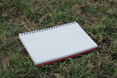 High angle view of open book on grassy field