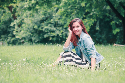 Portrait of beautiful young woman on field