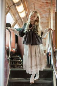 Portrait of girl standing on steps of bus