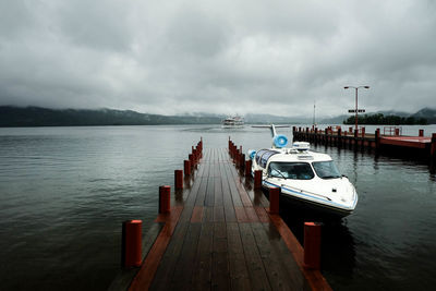 Motorboat moored at pier on caldera lake at akan national park