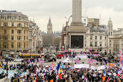 People on street against buildings in city