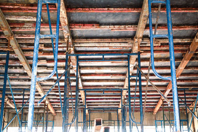 Setting up steel scaffolding to support floors for concrete work on tall buildings. a view up under.