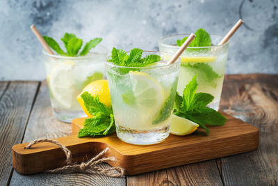 Two glass with lemonade or mojito cocktail with lemon and mint, cold refreshing drink.