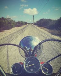 Close-up of motorcycle on road against sky