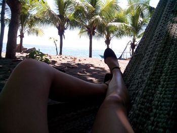 Low section of woman relaxing on beach