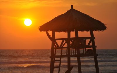 Lifeguard hut on beach during sunset