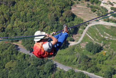 High angle view of man walking through rope in mid-air