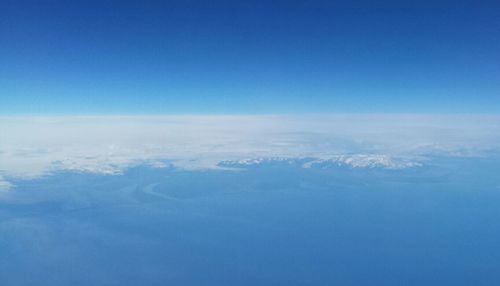 Aerial view of sea against blue sky