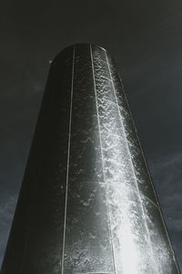 Low angle view of water spraying against sky at night